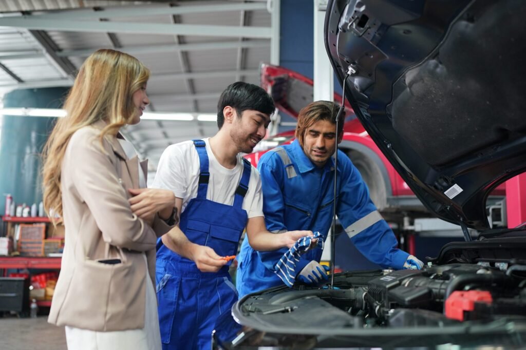 mechanic-in-blue-overalls-checking-serviceability-of-car-engine.jpg
